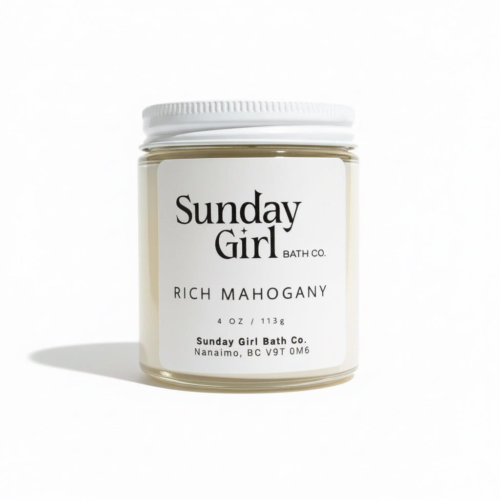 White candle labeled "Sunday Girl Bath Co" on a white backdrop