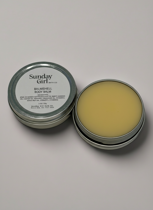 Open tin of Sunday Girl BalmShell Body Balm on a light gray background
