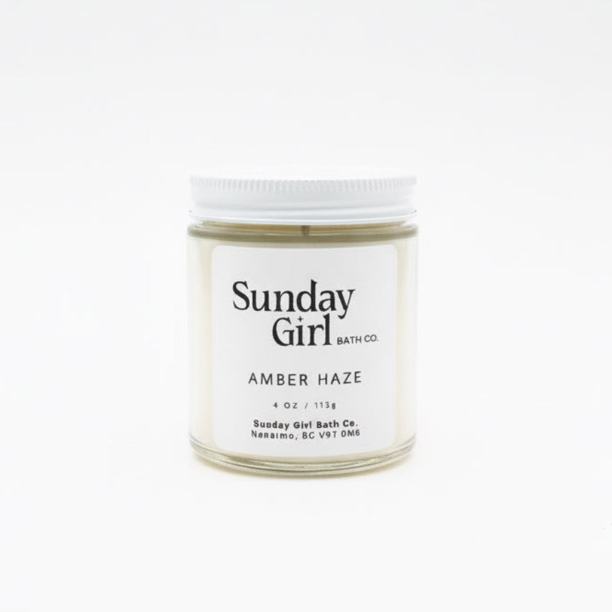 Candle jar labeled 'Sunday Girl' on a white background