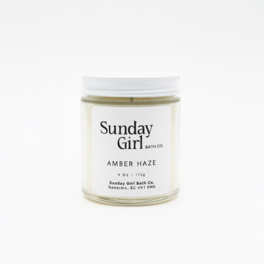 Candle jar labeled 'Sunday Girl' on a white background